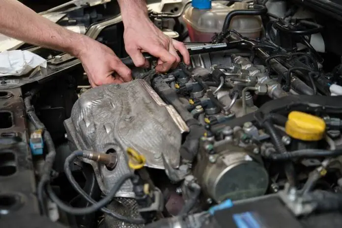Car mechanic hands replacing a camshaft position sensor
